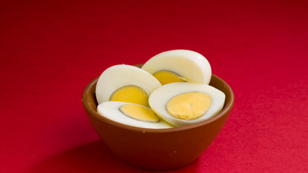 Boiled eggs in a wooden bowl highlighting egg consumption during pregnancy and prenatal nutrition.